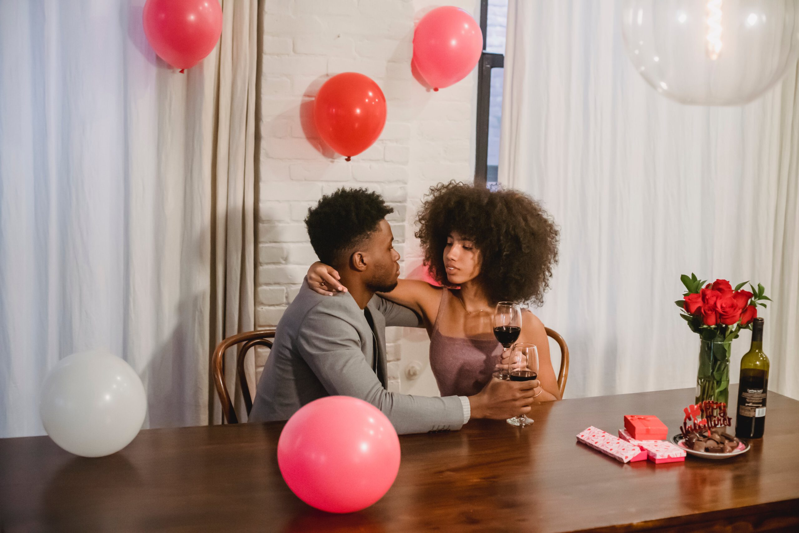 Illustration of Young African American couple drinking wine during celebration for the article titled Romantic DIY Home Bar Set-Up Ideas for an Intimate Valentine's 2024 Celebration photographed by Andres  Ayrton