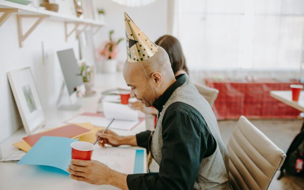 Featured image for the article "Spring Fever: Your Ultimate Party Planning Guide for Memorable April Celebrations 2024". showing A Side View of a Man Wearing Party Hat while Holding a Red Cup