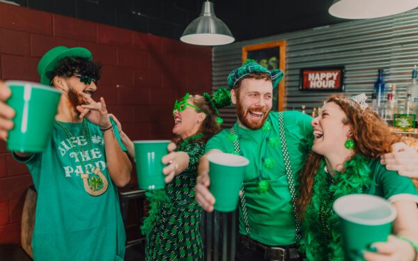 Featured image for the article "St. Patrick’s Day 2024: All You Need to Know About Irish Clubbing Fashion, Dance Moves, and Music". showing Happy Friends Together at a Pub