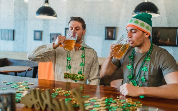 Featured image for the article "St. Patrick’s Day 2024: Crafting Unforgettable Irish Cocktails and Drink Games for Your House Party". showing Men drinking Beer Together